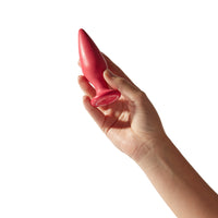 Plug anale Holly Dafne bio-based rosso magenta tenuto in mano su sfondo bianco