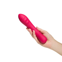 Vibratore in silicone color rosso Double Trouble, tenuto in mano per mostrare forma ergonomica e finitura morbida