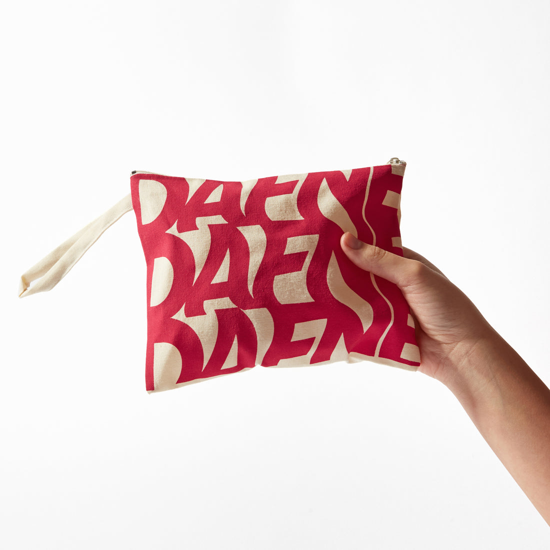 Pochette Dafne in tessuto con stampa rossa su fondo naturale, tenuta in mano, sfondo bianco