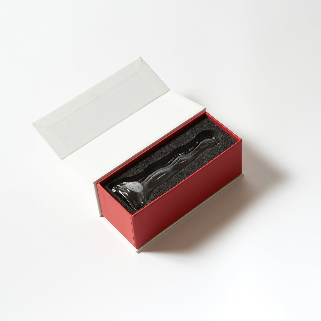 Petro dildo in vetro in confezione regalo Dafne, esposto all’interno della scatola magenta con coperchio bianco aperto