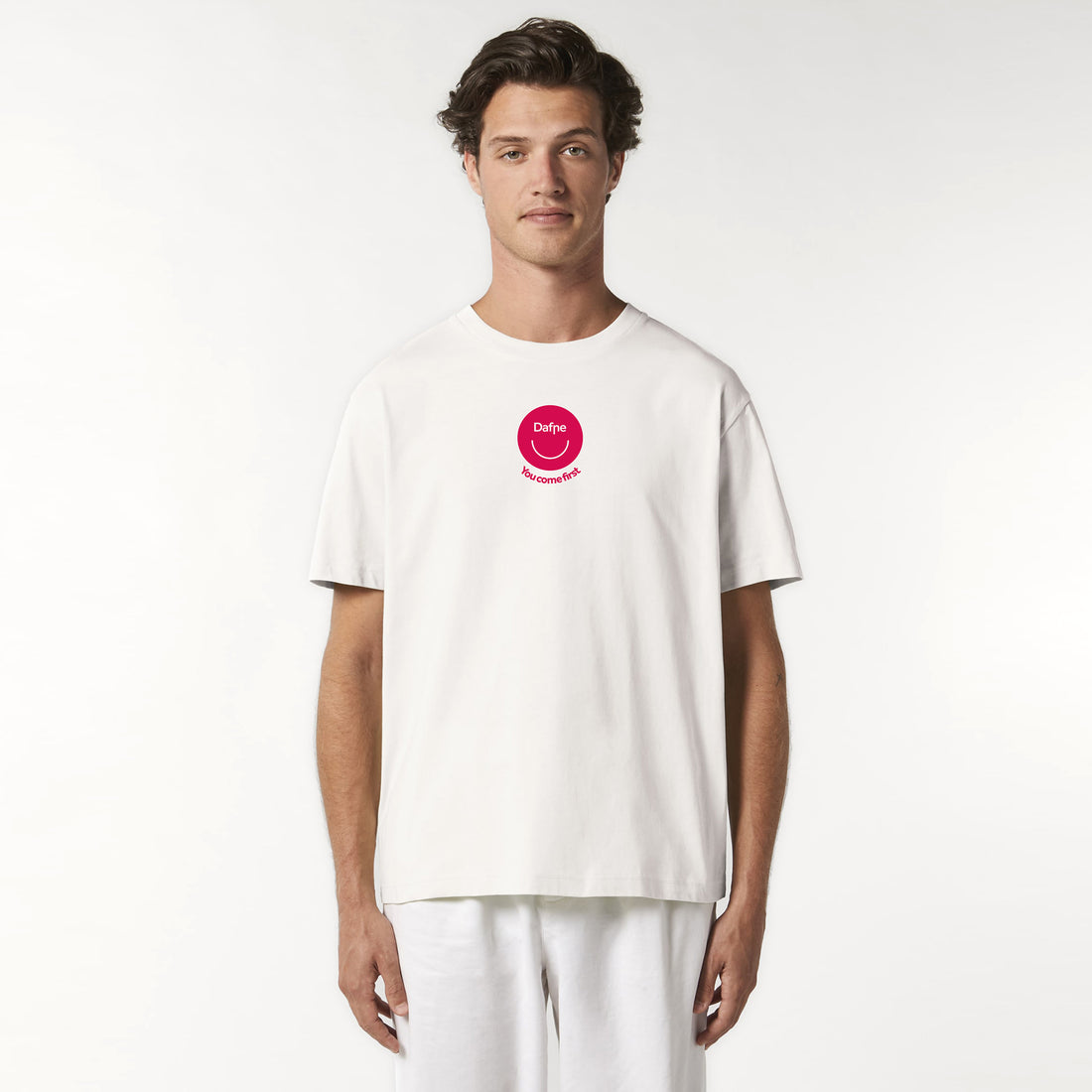 T-shirt unisex in cotone organico Dafne, colore bianco con logo rosso magenta sul petto, indossata da modello, su sfondo neutro