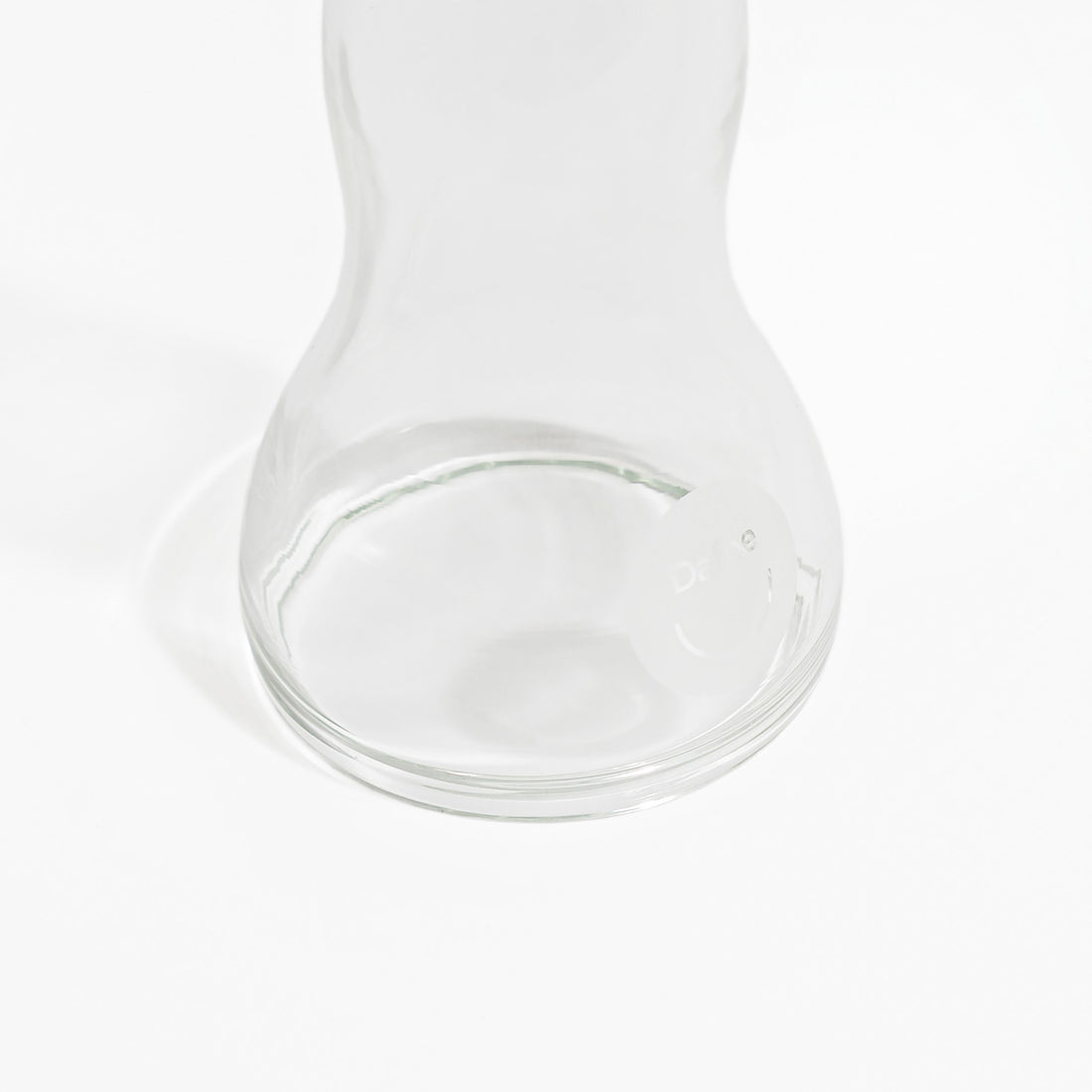 Dettaglio della base del dildo in vetro Dafne, con incisione del logo visibile su sfondo bianco